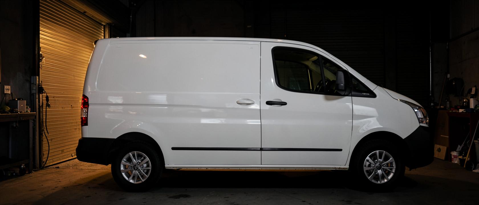 Pas gereinigde witte bestelwagen in een donkere loods in Zottegem