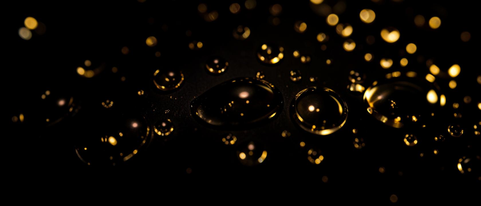 Water parelt in bolletjes op vers gecoate donkere autolak